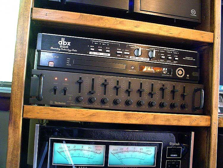 eq-amp-sacd.jpg - The black box with all the sliders and pots is a Technics SH9010 parametric equalizer. A recent addition, it replaces any one of several graphic eq's that I'd tried over the years. I was able to dial the system in perfectly and highly recommend it. Above that is an Oppo 980H SACD player, built specifically to be the best at SACD playback. It does video too, but that's more of an afterthought. Not an issue as this is a SOUND system. Above the Oppo is a dbx 200 switchbox which adds almost infinite capabilities to one tape loop.